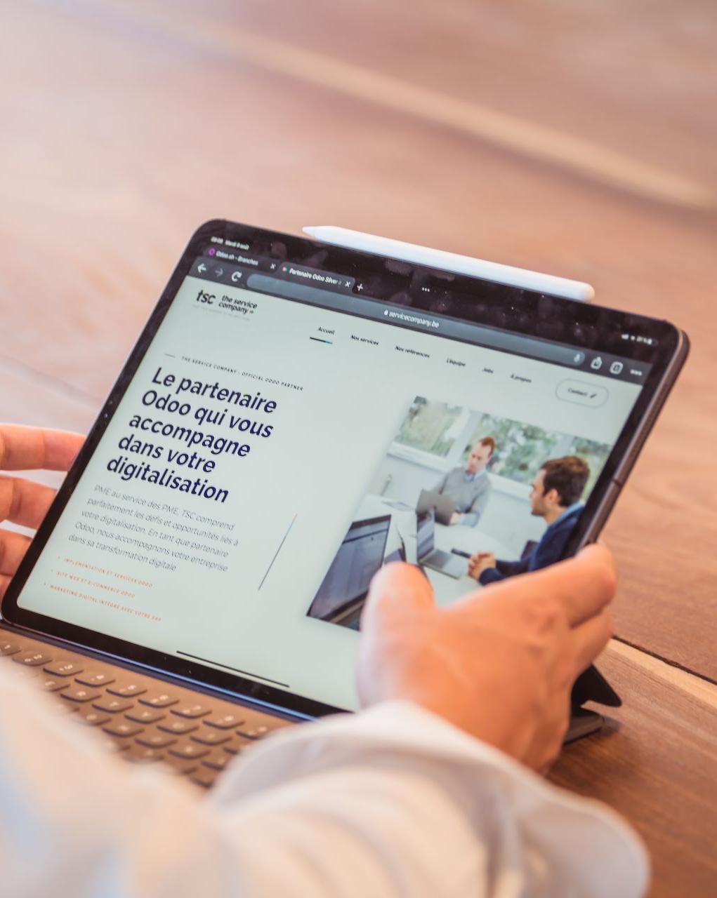 Un site web SEO friendly image d'une tablette Ipad avec affiché le site web internet officiel de l'entreprise the service company le partenaire odoo qui vous accompagne dans votre digitalisation une tablette posé sur une table de réunion