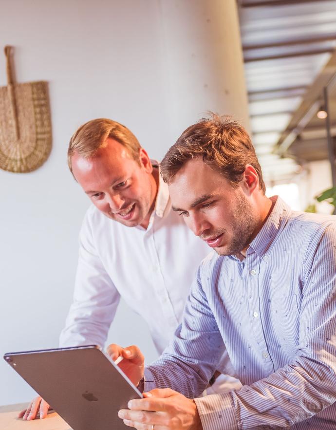 two people around an Ipad tablet to discuss the various points concerning Leave us your contact details to receive your guide